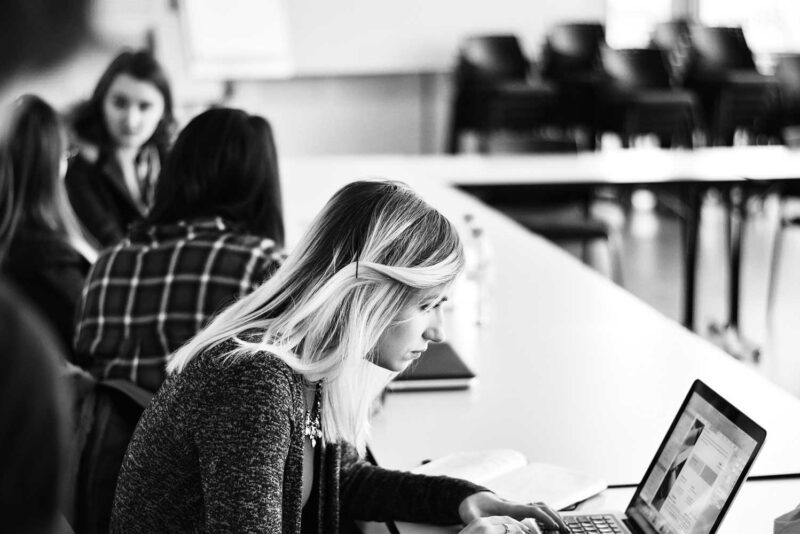 Student looking at laptop in a classroom