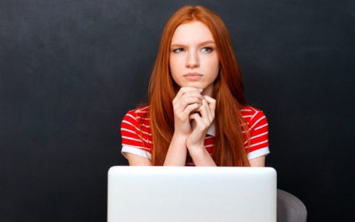 Girl contemplating in front of her laptop