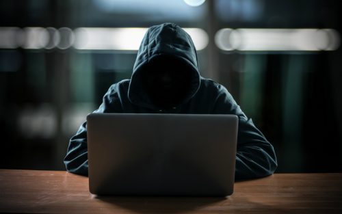 Mystery person working on a laptop