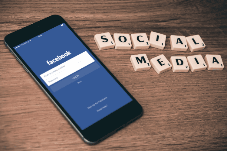 Facebook on a smartphone with the tile letters spelling social media