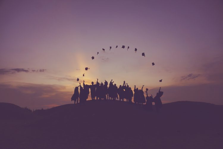 graduates' silhouette against the sunset