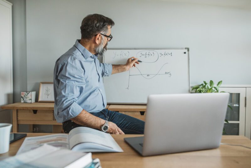 A teacher is teaching over his laptop
