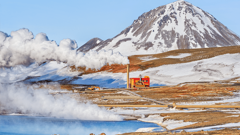 Mountain landscape with water, clouds and red building