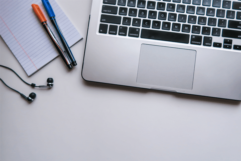 Computer, notepad, pens and earphones