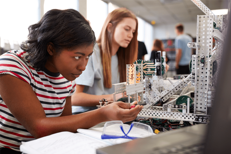 African American science student looking at a robot